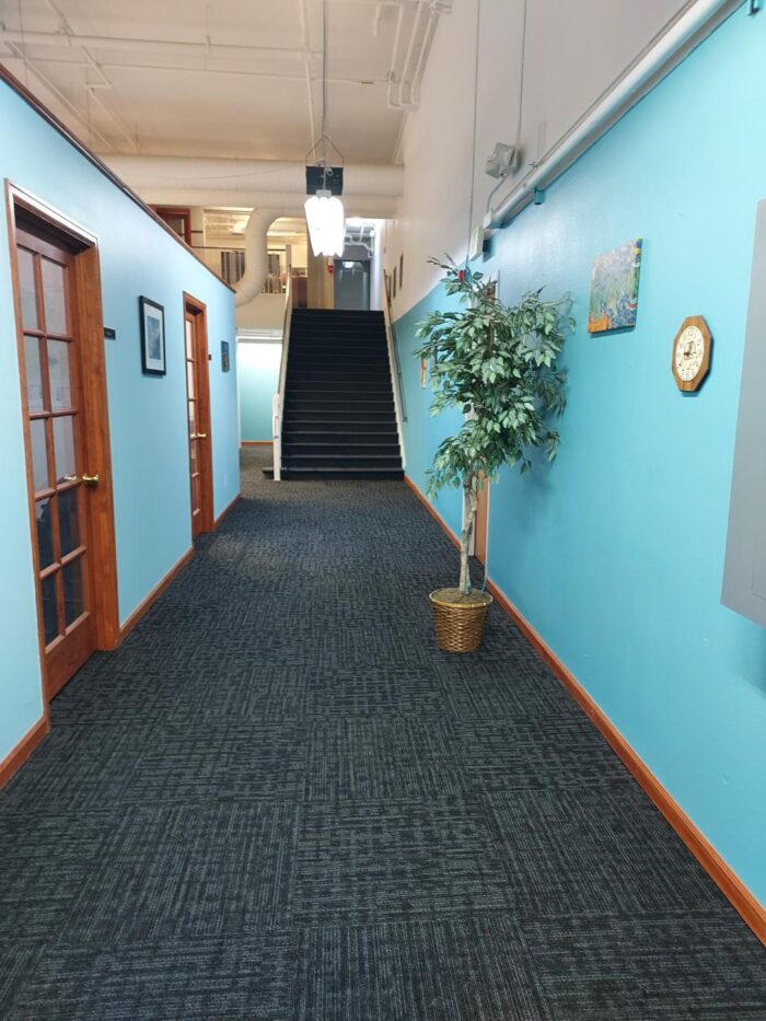 A corridor with turquoise walls and two office doors as part of 17th and Central Executive Suites.